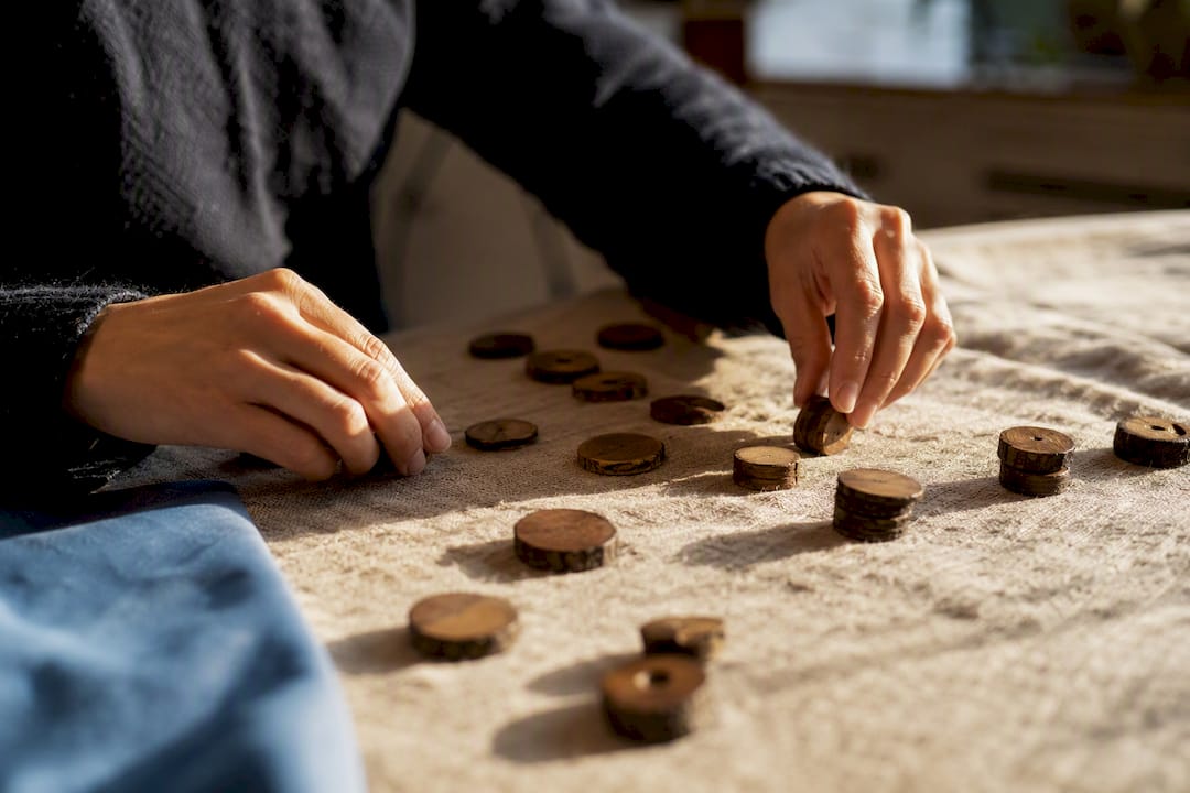 Hands arranging transaction tokens on wood
