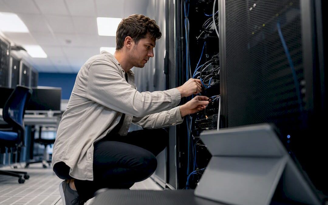 Hands connecting cables in a data center